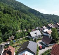 A view of picturesque cottages in Špania Dolina near Banská Bystrica, surrounded by dense forests.
