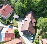 An aerial view of a cottage in Špania Dolina near Banská Bystrica surrounded by greenery and houses.
