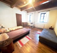 A cabin with two sofas, a floor with a wooden decor, and a wooden ceiling.