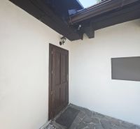 Entrance to the cottage in Špania Dolina with a stone terrace and wooden elements.