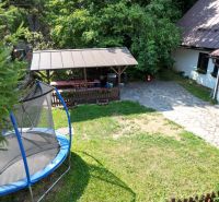 A yard of a cottage on Špania Dolina street in Banská Bystrica with a trampoline and a gazebo.