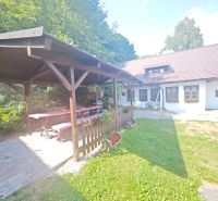 A cottage in Špania Dolina with a gazebo, wooden table, and floral decorations in the garden.