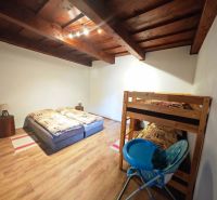 A room in a cottage with a wooden floor and a bunk bed.