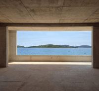 A view from a 4-room apartment of the sea and islands through a large window.