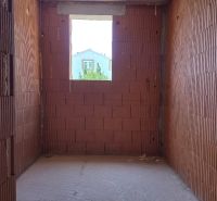 Red brick walls prepared for a 4-room apartment, with a view of the surrounding houses.