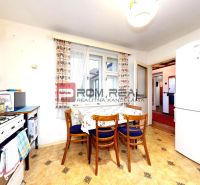 A kitchen in a family house with a gas stove, a table, and chairs, with a wooden decor floor.