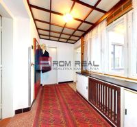 Hallway with carpet and wardrobe, family house, wood-decorated ceiling, bright windows.