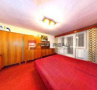 A bedroom with a red carpet and wooden furniture in a family house.