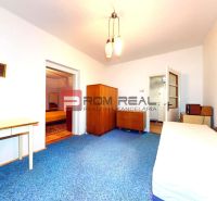 A room in a family house with wooden furniture and a blue carpet on the floor.