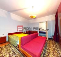 Bedroom in a family house with a carpet, mirror, and red sofa.