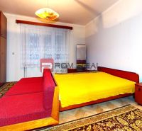 Bedroom in a family house with a bed, wardrobe, mirror, and floor with wooden decor.