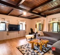 A living room in a cottage with a wooden decor floor and comfortable seating.