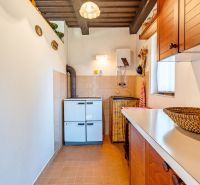 A kitchenette in a cabin with white walls, brown cabinets, and appliances.