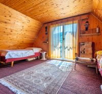 Wooden paneling, carpets, and a bed in the interior of the cabin create a cozy atmosphere.