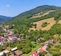 Aerial view of Lazy pod Makytou, Dubková, surrounded by picturesque nature and hills.