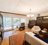 Living room in a family house with carpeted floor, furniture, and television.