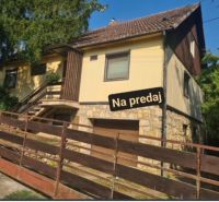 A family house in Svodín, with stone foundations and a wooden fence, is for sale.