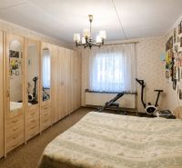 A bedroom in a family house with a large wardrobe, a bed, and exercise equipment.