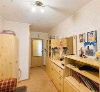 Interior of a family house with wooden furniture, a carpet, and photographs on the wall.