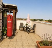 Terrace of a 1-bedroom apartment with seating and a punching bag on Čerešňová Street in Chorvátsky Grob.