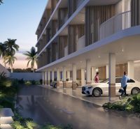 Apartment construction in Surat Thani: parking under a modern building surrounded by tropical greenery.