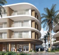 Construction of apartments in Surat Thani with curved balconies and palm trees in the background.