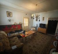 Living room in a family house with antique furniture, a sofa bed, and a television.