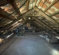 Attic in a family house with wooden beams and roof structure.