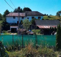 A family house in Stará Turá with a garden, fencing, and extensions, with a view of the countryside.