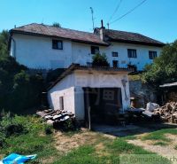 A family house in Stará Turá with a garage and cut wood in the yard.