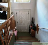 A staircase with a shoe rack and white doors in a family house.
