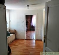 The interior of a family house with a wooden decor floor, light walls, and doors.