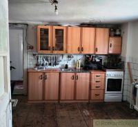 A kitchen in a family house with a wooden decor floor and wooden cabinets.