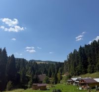 Recreational plots in Litmanová surrounded by forests and blue skies.