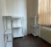 Office with shelves, a radiator, and curtains, floor with wood decor.