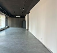 Spacious offices with wood-decor flooring, white walls, elegant lighting.