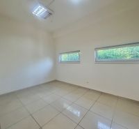 A commercial space room with ceramic tiles and two windows.