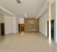 Interior of a commercial space with a stone wall and tiled floor.