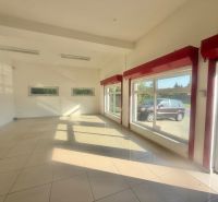 Commercial spaces with large windows, tiles, and white walls.