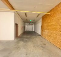 Spacious commercial spaces with concrete floors and wooden walls.