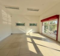 Interior of a commercial space with large windows and glossy tiles.