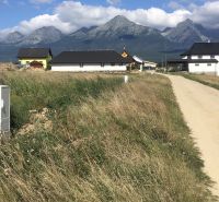Residential plots in Mlynica with a view of the mountains and a dirt road.
