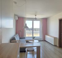 Living area of a 2-room apartment with a kitchen table and a wooden decor floor.