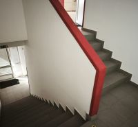 A staircase with a red railing in commercial premises, tiled floor.