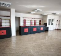 Commercial premises with tiles, black and red counters, shelves, and racks.