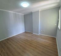 Bright room with wood-patterned flooring in a Holiday Apartment.