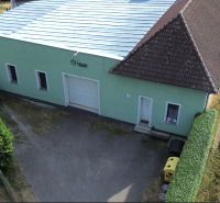 Production premises in Budča with a metal roof and an adjacent road.