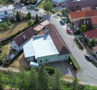 Aerial view of manufacturing facilities in the village of Budča, surrounded by greenery and houses.
