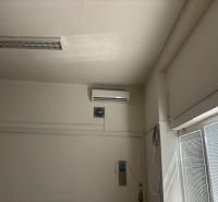 Ceiling air conditioning in commercial spaces with white blinds on the windows.