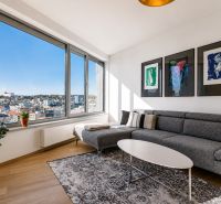 Living room in a three-room apartment with a wooden decor floor and a view of the city.